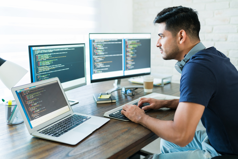 Handsome Young Male Programmer Coding At Desk